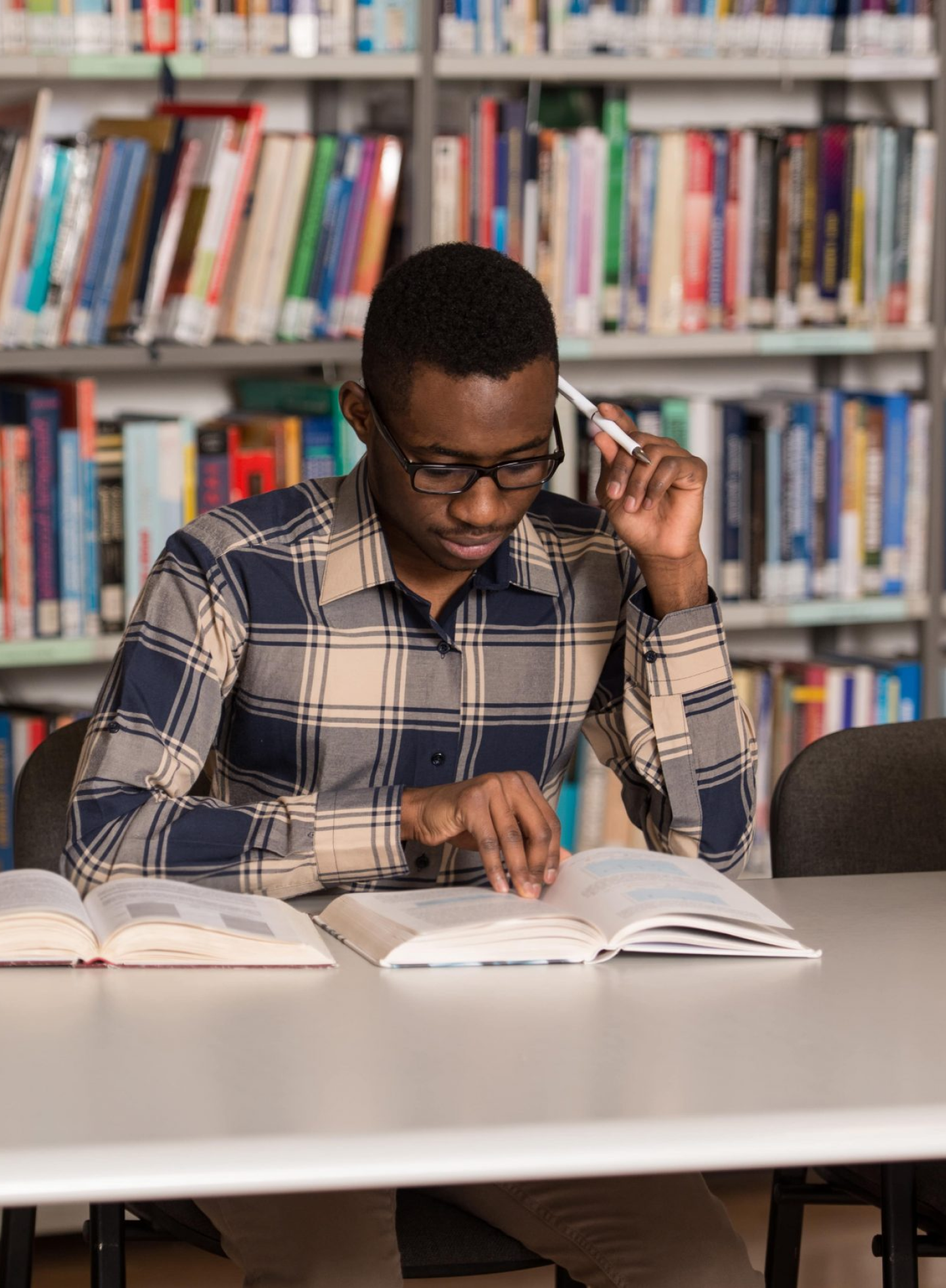 Focused young man studying in a library, representing dedication to personal growth and self-improvement.
